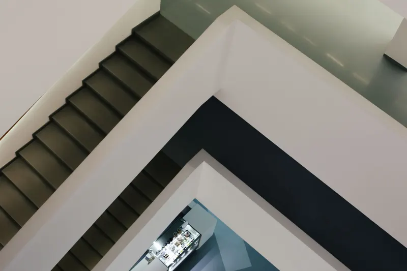 Plusieurs volées d'escalier reliées par des paliers à l'intérieur d'un bâtiment.